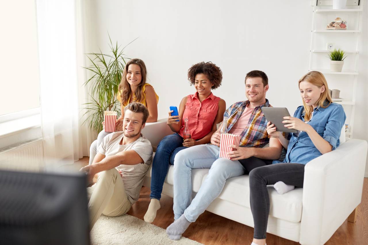 Nejlevnější mobilní tarif - rodina na gauči sleduje televizi jako bonus k mobilnímu tarifu